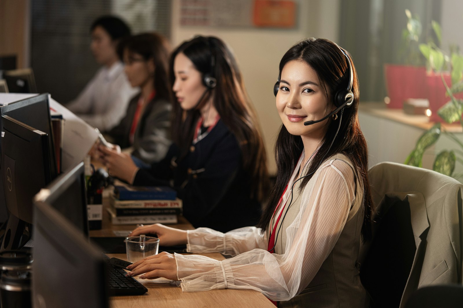 Skiptracers wearing headsets at their desks in a call center.